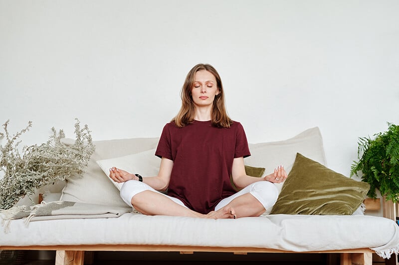 Vrouw op meditatie kussen mediterende